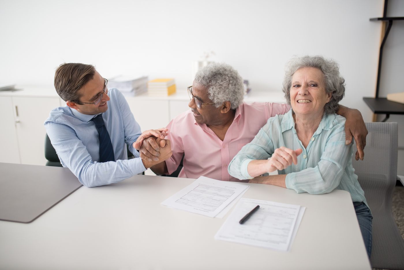 A Wakairu adviser meeting with two clients over financial documents