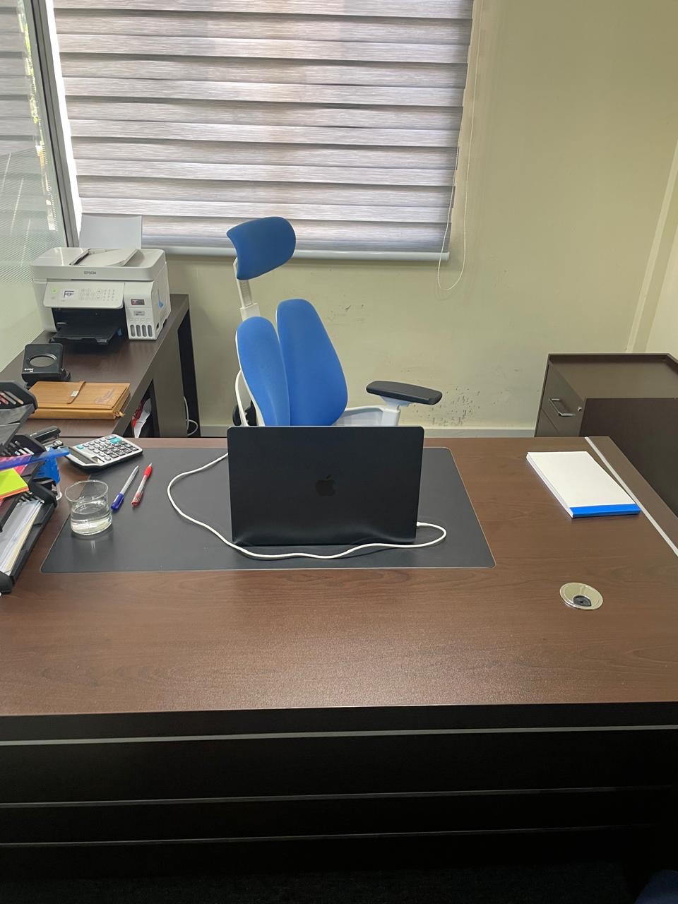 A partner's desk at the Wakairu office with laptop and calculator